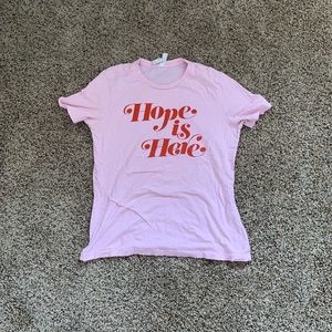 Pink shirt with lettering “Hope is Here”